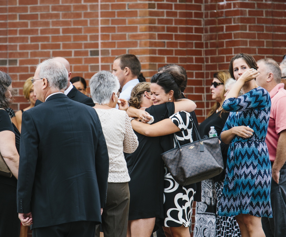 Family, friends and members of the Saco community embrace after services for Wendy Boudreau at Thornton Academy in Saco on Tuesday.