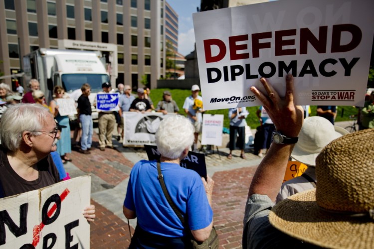 Gary Anderson of Bath holds up a sign as he and other activists gather in Portland's Monument Square on Wednesday to urge Sen. Susan Collins to back the Iran nuclear agreement. Collins has not yet disclosed her position.
