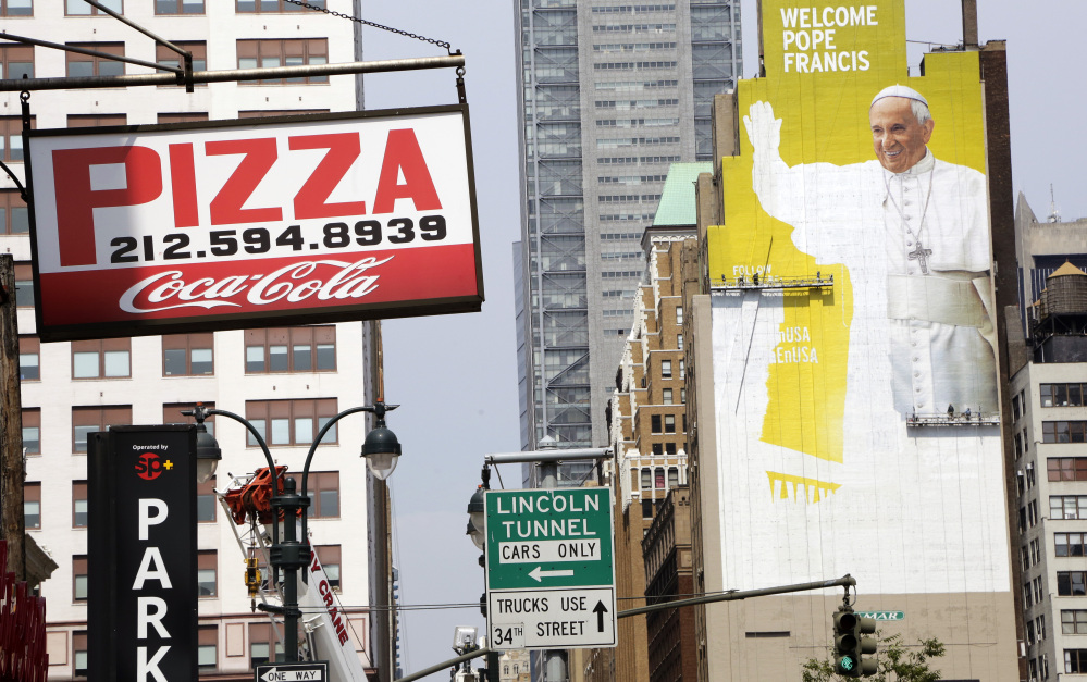 Sign painters work on a portrait of Pope Francis on the side of a New York City office building in preparation for his first U.S. visit next month, with stops in Washington, D.C., New York and Philadelphia.