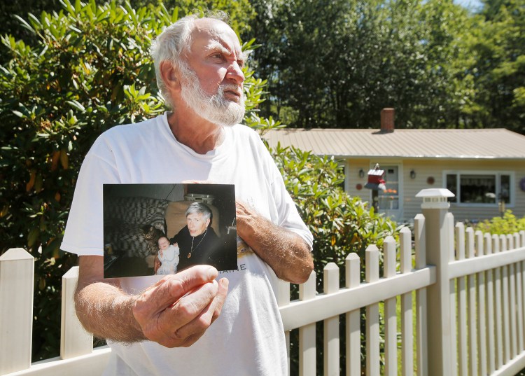 Robert Douglas shows a photo of his wife, Rita, holding their granddaughter Harley in a family photo taken 17 years ago.
Gregory Rec/Staff Photographer