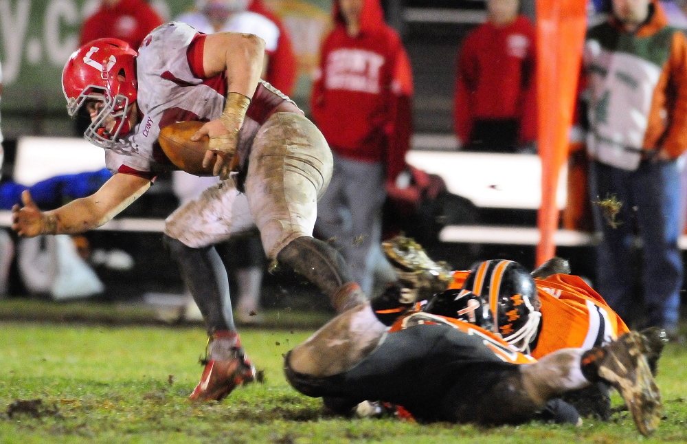 Stafff file photo by Joe Phelan
FIGHTING FOR YARDS: Cony running back Reid Shostak, left, gets tripped up by Gardiner defenders during the annual rivalry game last fall. Shostak leads a Cony team that hopes to contend in tough Pine Tree Conference Class B.