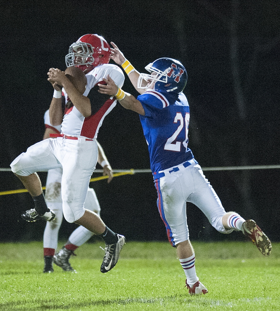 Kevin Bennett photo 
 Cony receivers Joey Younes, left, catches a pass under pressure from Messalonskee's CJ Gordon during the second quarter of a Pine Tree Conference Class B game Friday night at Veterans Field in Oakland.