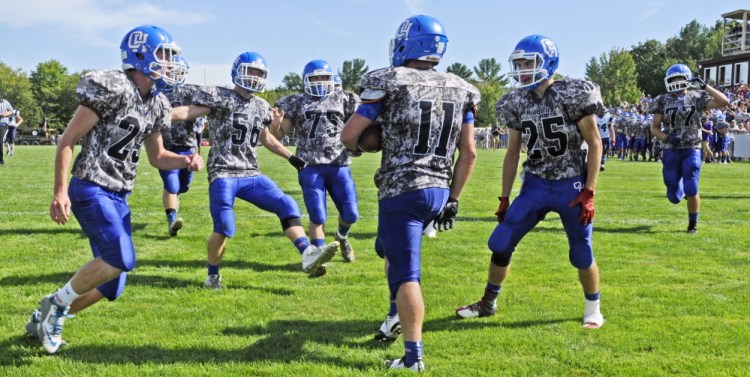 Oak Hill teammates run into congratulate Jonah Martin (11) after he scored on a long touchdown catch in second quarter against Dirigo on Saturday.