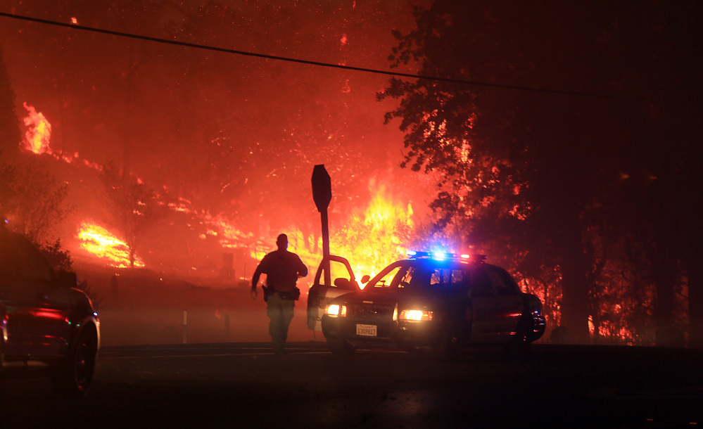 Lake County sheriff’s officers  prepare to evacuate Butts Canyon Road in Middletown, Calif., as the Valley  fire jumps Hwy 29, on Saturday.