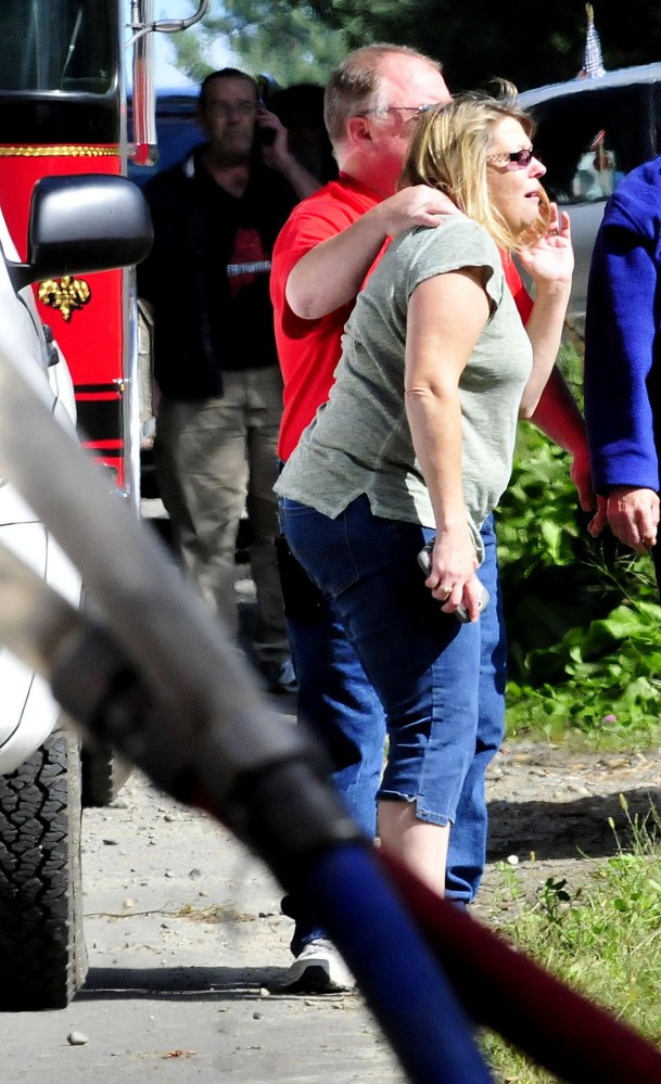 Distraught homeowner Carol Ann Manson is comforted by a neighbor as her home in Oakland is destroyed by fire on Monday. Manson was upset at the possible loss of her three dogs and a cat, who hadn’t been found.