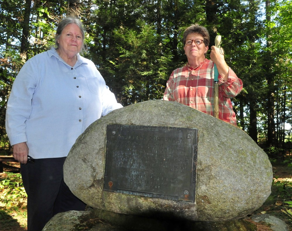 Deborah Staber, left, of the L.C. Bates Museum in Hinckley, and Melissa Bastien, stop along the nearby Dartmouth yrail beside the Roosevelt monument on Monday.