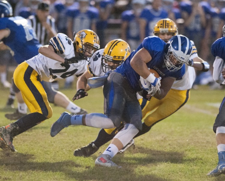 Lawrence’s Mitchell Cushing carries the ball for short yardage during first-quarter action against Mt. Blue on Friday in Fairfield.
