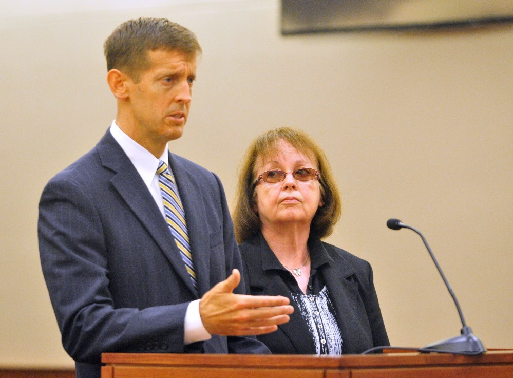 Attorney Walter McKee stands with Claudia Viles as she pleads not guilty plea in an initial appearance on Thursday in Kennebec County criminal court in Augusta. She is charged with 13 counts related to tax fraud at the Anson Town Office.