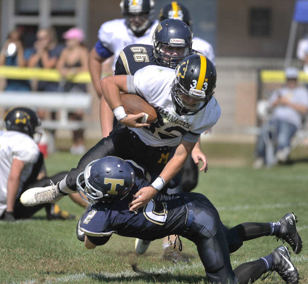 Traip Academy vs. Maranacook football game. Traip's #2, David Gibson, cuts down Maranacook running back Zach Lacasse after a short gain. 