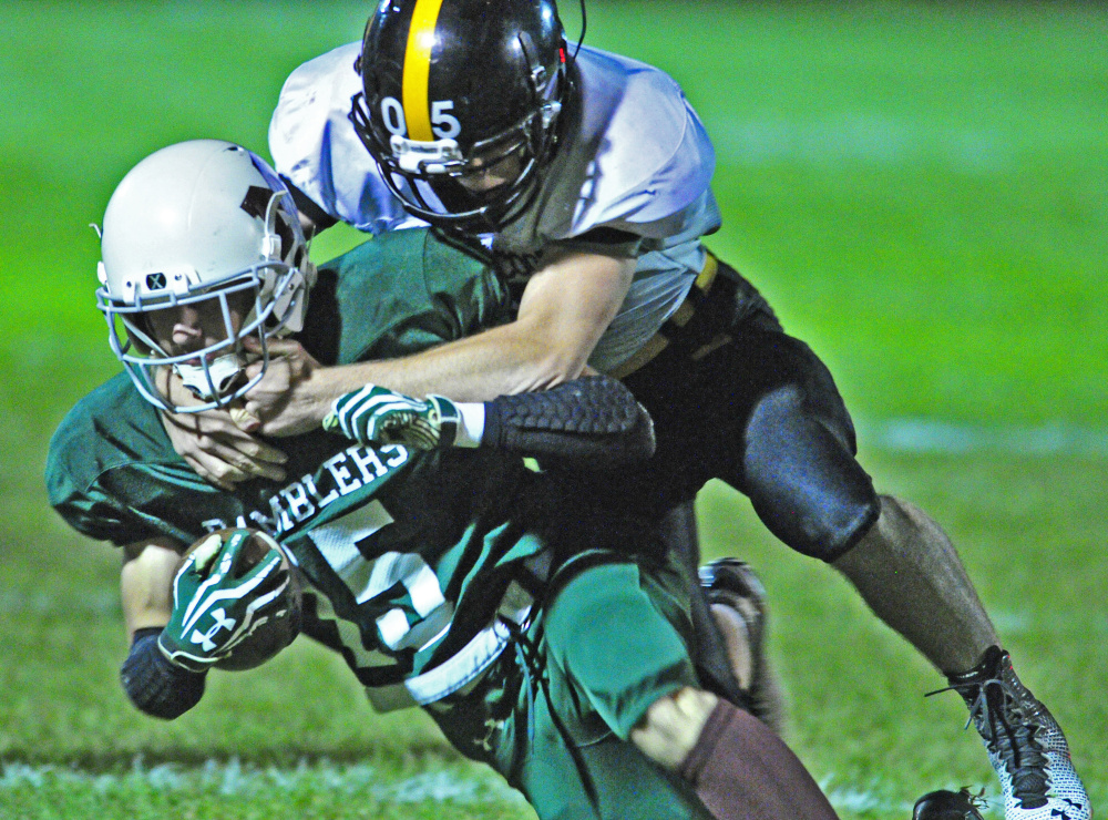 Staff photo by Joe Phelan 
 Winthrop/Monmouth's  Andrew Pazdziorko, left, gets taken down by Maranacook's Brandyn Michaud during a game Friday at Maxwell Field in Winthrop.