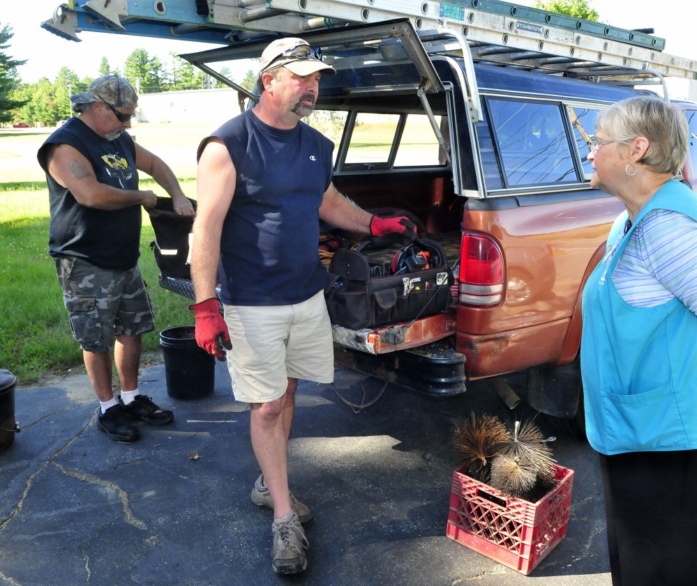 Staff photo by David Leaming
John Beane, center, speaks with Skowhegan homeowner Judy Hilton before Beane and Gary Witham cleaned her chimney on Thursday. Hilton said she makes sure her chimney is cleaned yearly for peace of mind.