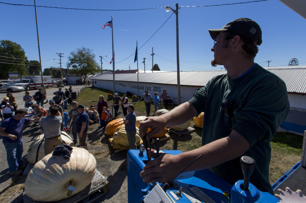 Crane operator Andy Dugas helps lower a pumpkin onto a scale Sunday. The contest had several categories, including giant squash, traditional pumpkins and a youth division.