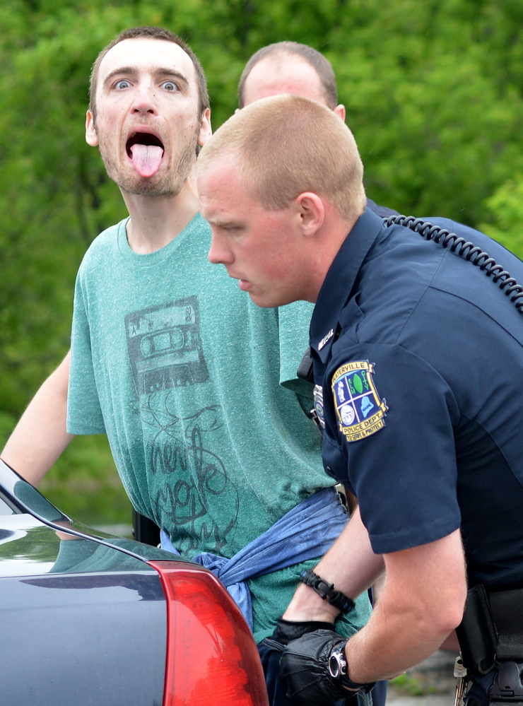 Waterville officer Chase Fabian, foreground, frisks Jesse J. Peterson at Head of Falls in Waterville in this June file photo.