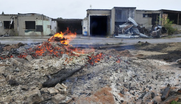 A debris is burned behind the former Witlon Tanning company on Tuesday. New owner John Black is repairing and renovating the large structure including roof replacement for his businesses and other companies.