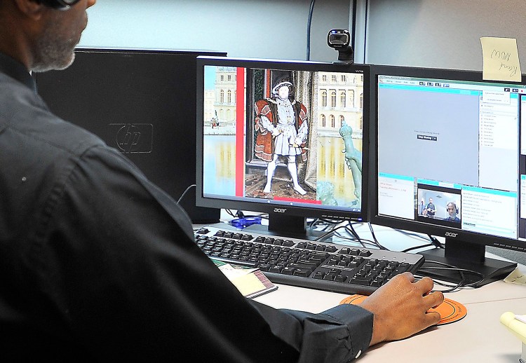 Kern Philgence a social studies teacher for Maine Connections Academy, holds a live English history lesson with students on computers at home in November of last year. The virtual charter school is at capacity this fall, with 396 students.
Gordon Chibroski/Staff Photographer