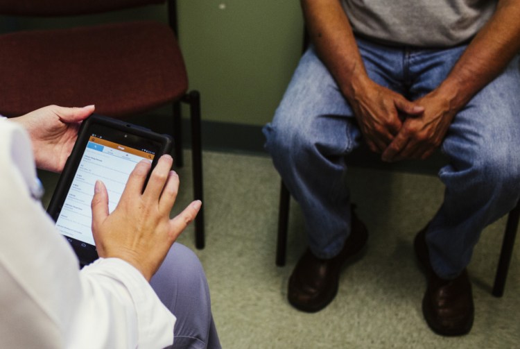 Physician assistant Molly Boyd uses the Health eVillage tablet while assisting a patient at the Harrington Family Health Center in Harrington, a small coastal community in Washington County. The tablet is loaded with medical apps that provide “an electronic library at your fingertips,” said Lee Umphrey, CEO of the health center.