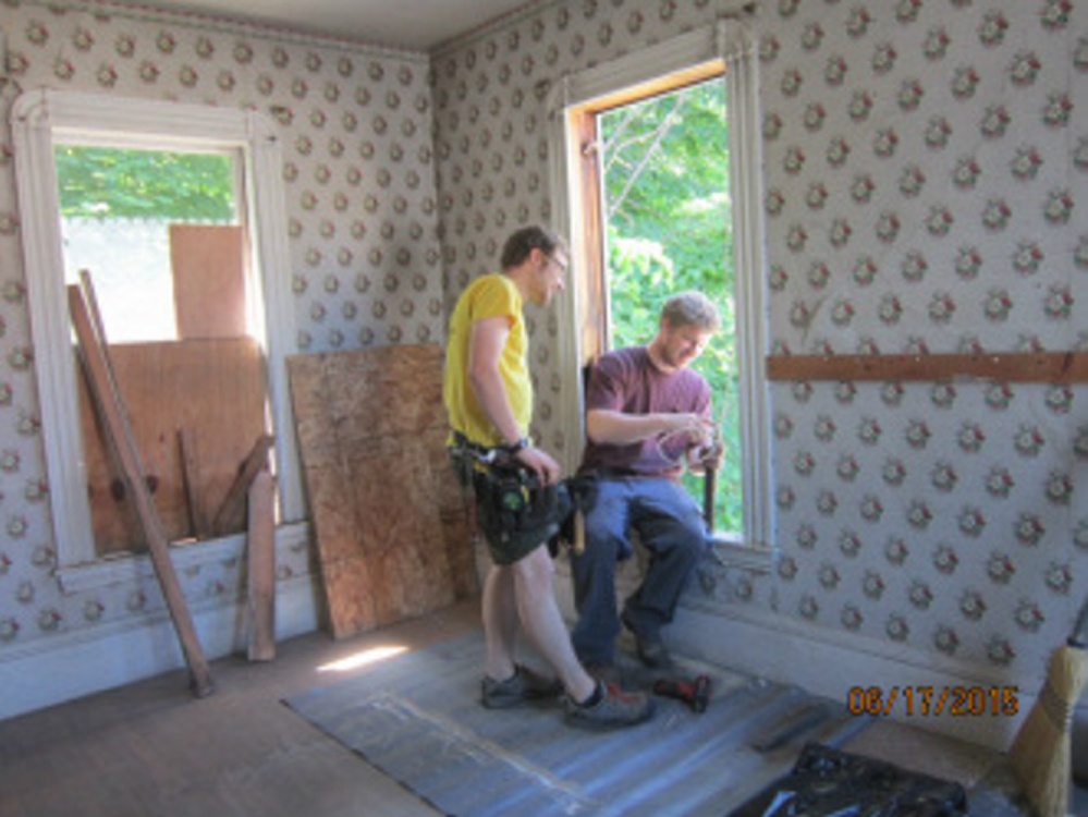 Philip Walter and Tim Sweeney of Bagala Window Works attach the original window weights to new sash cords of restored windows.