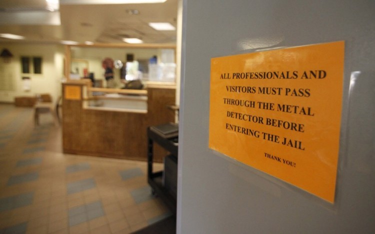 A sign on a metal detector at the Cumberland County Jail in Portland advises that everyone must pass through. Underwire bras are apparently setting off the detector.