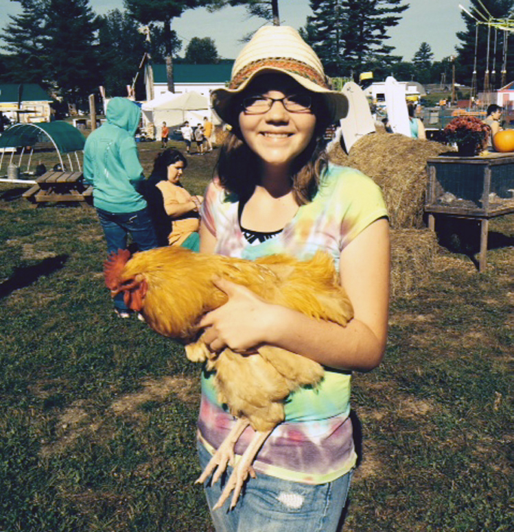 Lia Herrick, 13, of Harmony, holds Reggie, her 3-month-old rooster, which she showed in the poultry show Saturday at the Harmony Free Fair in Harmony.