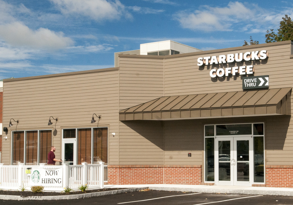 James Merrill checks the door of a Starbucks coffee shop Thursday in Journal Square in Augusta. Just built but not open yet, it is one several new businesses that are coming soon to Western Avenue.