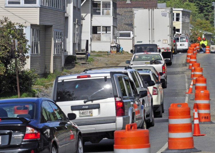 A flagger directs traffic on Monday in the one-way section of Mount Vernon Avenue in Augusta.