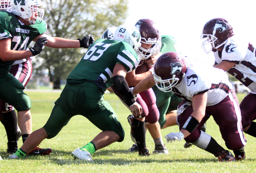 Photo by Jeff Pouland 
 Mount View High School's Ethan Sewell-Berry (63) tackles Maine Central Institute's Adam Bertrand during a Litte Ten Conference game earlier this season in Thorndike.