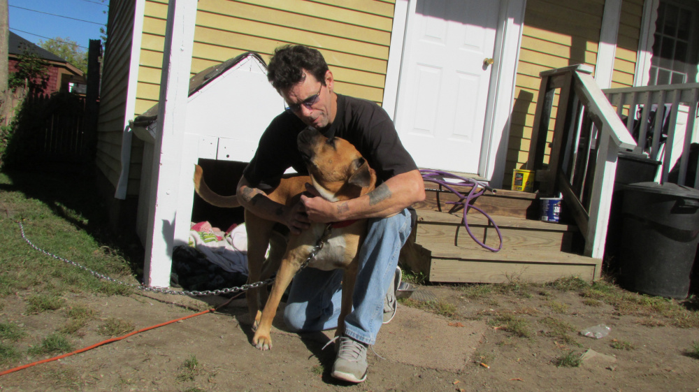 Darryl Roberts plays with his dog, Vega, outside his Water Street apartment in Waterville Thursday afternoon. The Humane Society Waterville Area is targeting low-income neighborhoods in the city for free pet health services as part of a pet wellness outreach program.