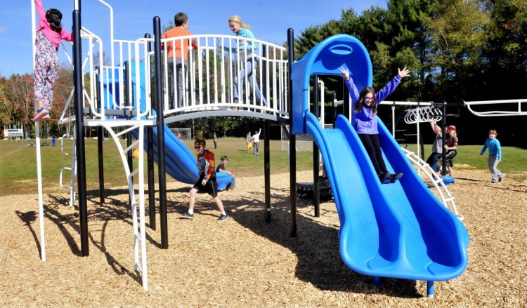 Kali Hale throws out her arms as she and other Canaan Elementary School kids play on equipment bought through a community effort that included two years of fundraising and help from the New Balance Foundation.