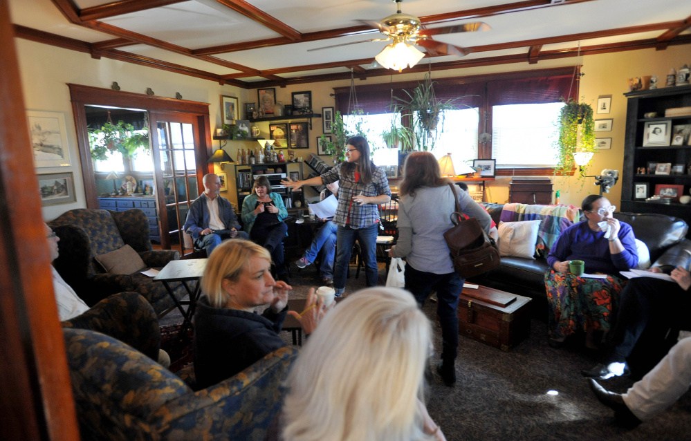 Jackie Dupont, back center standing, calls the South End Neighborhood Association meeting to order at the residence of Chris Moody on Summer Street in Waterville on Saturday. The meeting included a discussion about a new program that helps low-income residents get health care for pets.