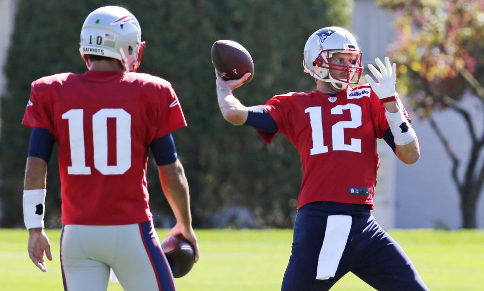 New England Patriots quarterback Tom Brady  throws a pass as back-up quarterback Jimmy Garoppolo (10) watches at practice Wednesday in Foxborough, Mass. The Patriots traveled to Dallas to face the Cowboys today. At rear left is offensive coordinator Josh McDaniel.
