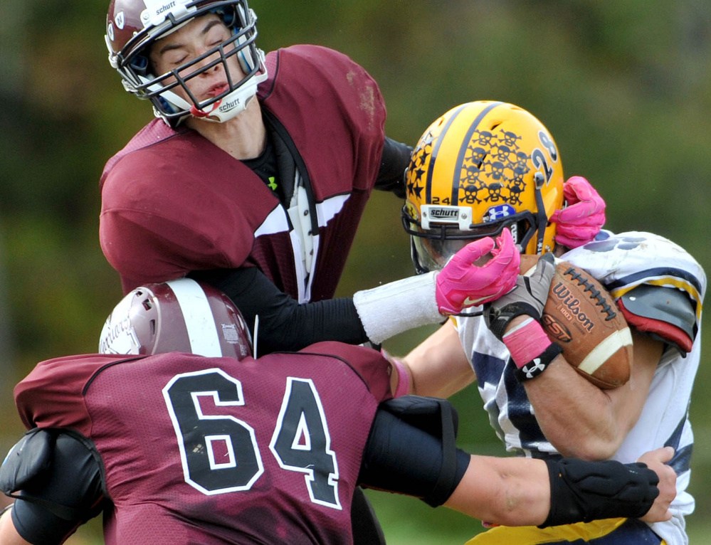 Nokomis High School defenders Mike Massow (1) and Jake SeeHusen (64) tackle Mt. Blue High School’s Christian Whitney (28) on Saturday in Newport.