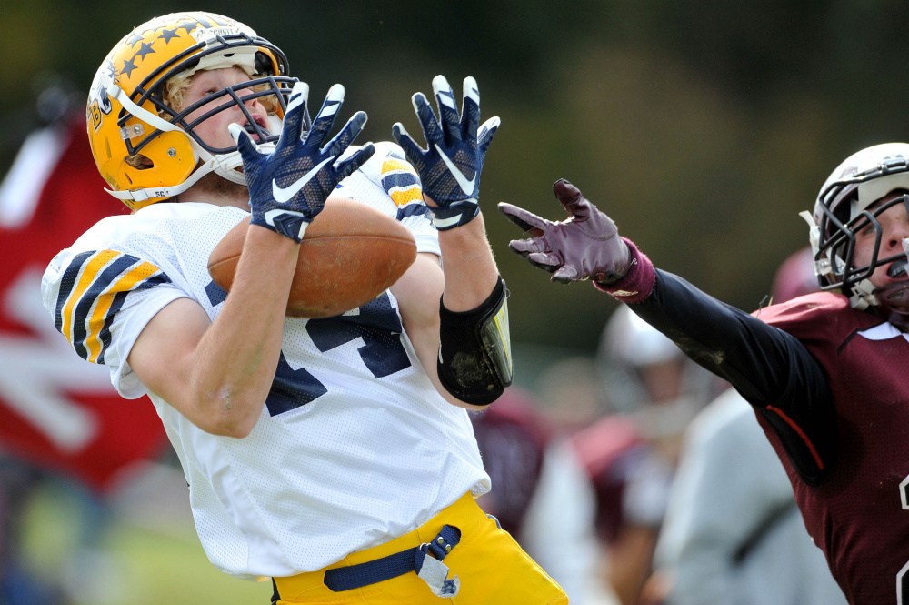 Mt. Blue High School’s Nate Pratt-Holt (14) lets a ball pass through his hands for the incompletion as Nokomis High School’s Colby Pinette (20) defends Saturday in Newport.