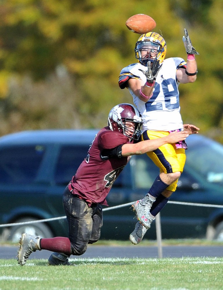 Mt. Blue High School’s Christian Whitney (28) eyes the ball as Nokomis High School’s Cody Rice (42) defends Saturday in Newport.