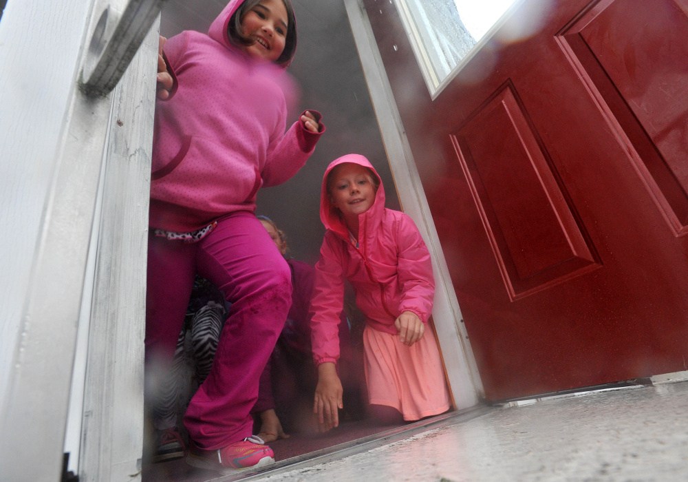Canaan Elementary School fourth-graders Natasha Rairdon, left, and Julia Fitzgerald, right, escape a mock house fire during a fire safety class at Canaan Elementary School in Canaan on Friday,