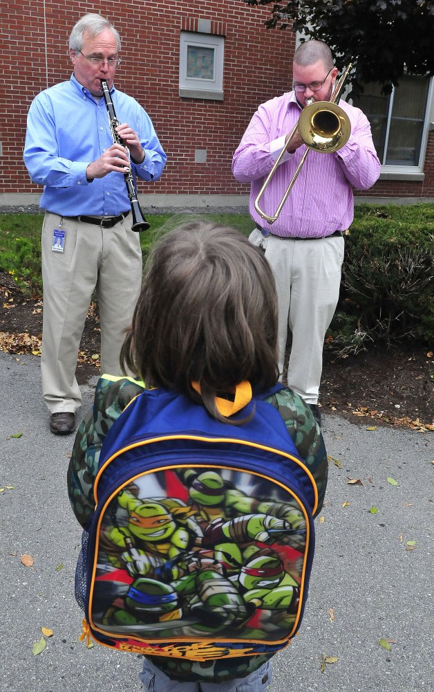 Benton Elementary School music teachers David Hoagland, left, and Josh Lund play instruments to an appreciative Jackson Jones after he arrived for school on Tuesday. “I like that music,” Jones said.