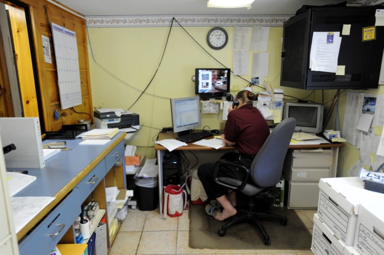 Kathy Gray, dispatcher for the Oakland Police Department, works at her desk earlier this year. Townspeople will vote Nov. 3 on a plan for a new station. There is a public hearing on the plan Thursday night.