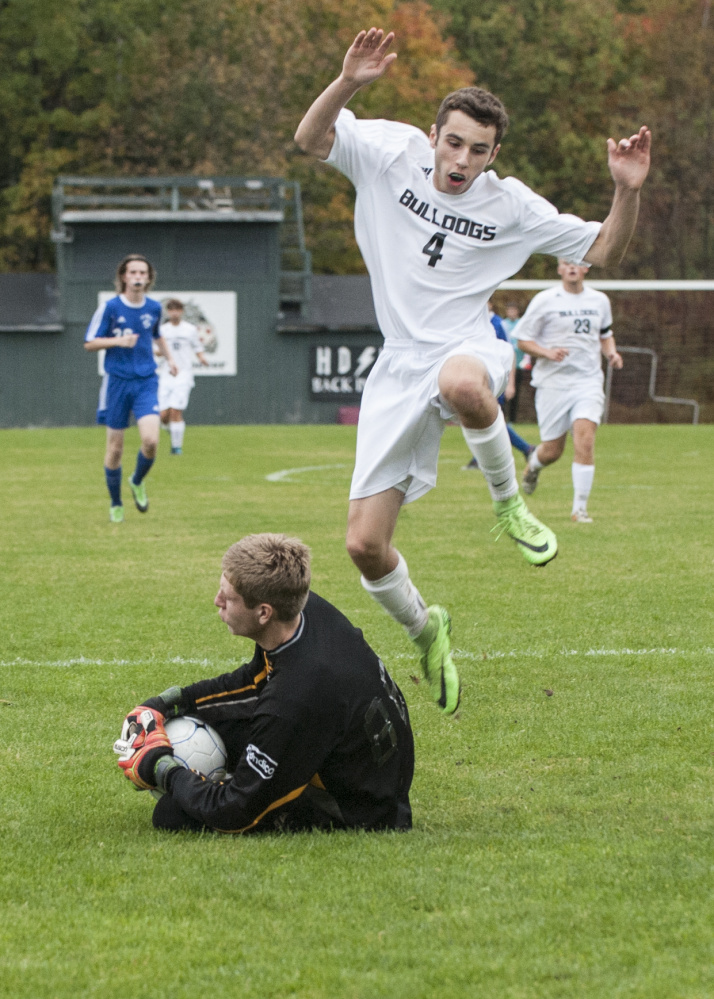 Contributed photo/Marty Thornton 
 Hall-Dale's Tyler Nadeau jumps over Mt. Abram eeper Seth Thomas after Nadeau got a shot on net during a Mountain Valley Conference game Tuesday in Farmingdale.