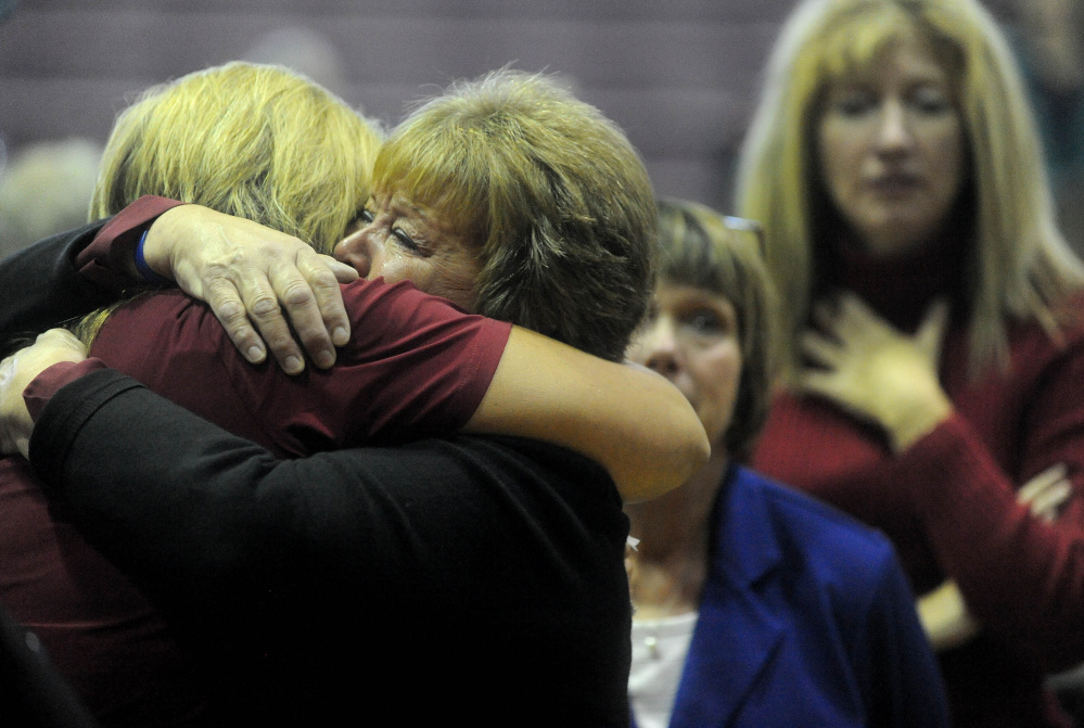 Friends of Michael Holland extend their condolences to his mother, Deborah Holland Roberts, far left, during a celebration of Michael’s life at the Jay Community Building on Wednesday.