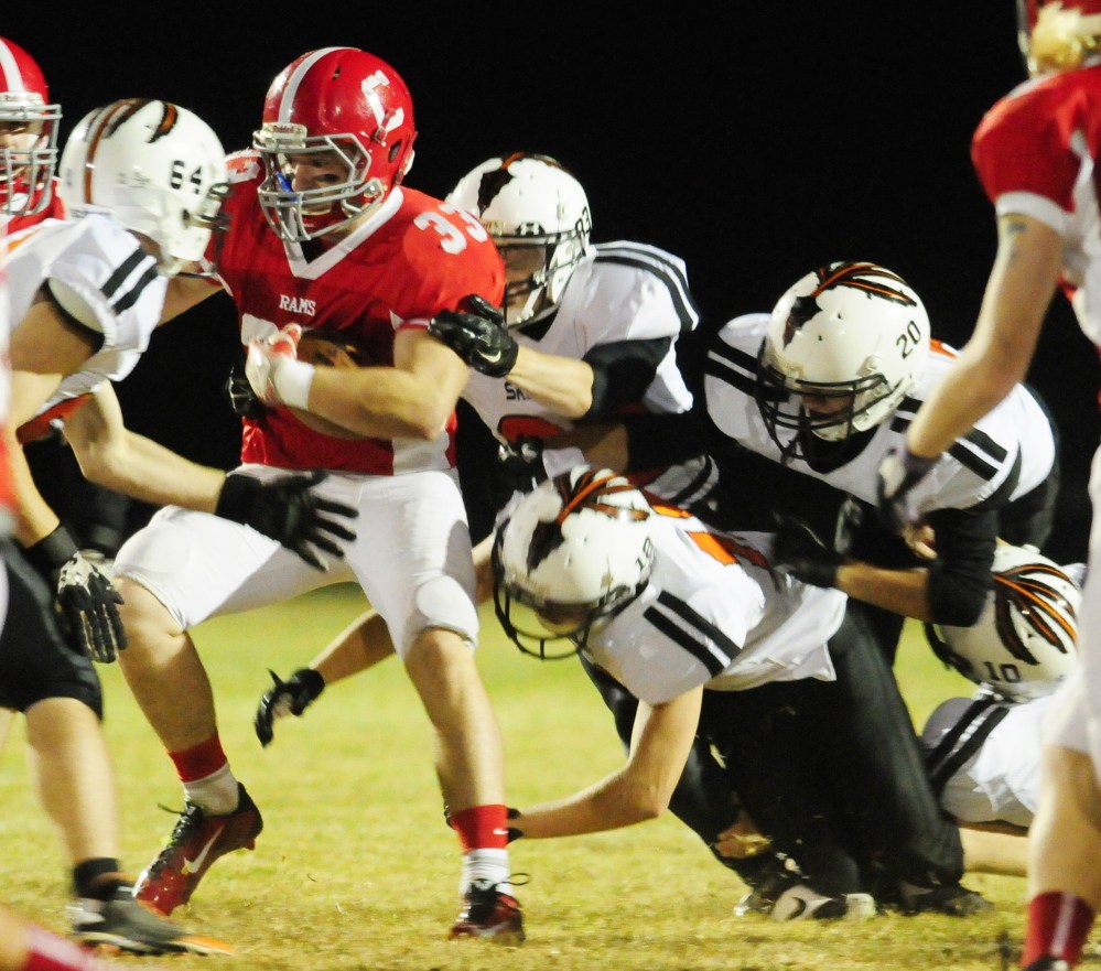 Cony running back Reid Shostak is surrounded by a swarming Skowhegan defense during a Pine Tree Conference B game last season at Alumni Field in Augusta.