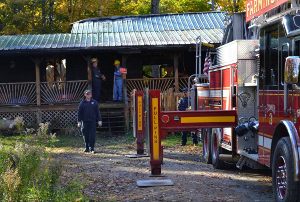 Firefighters check the home at 120 Vacation Estates off Holley Road in Farmington Wednesday after a fire destroyed the house. The Bates family lost a number of pets.