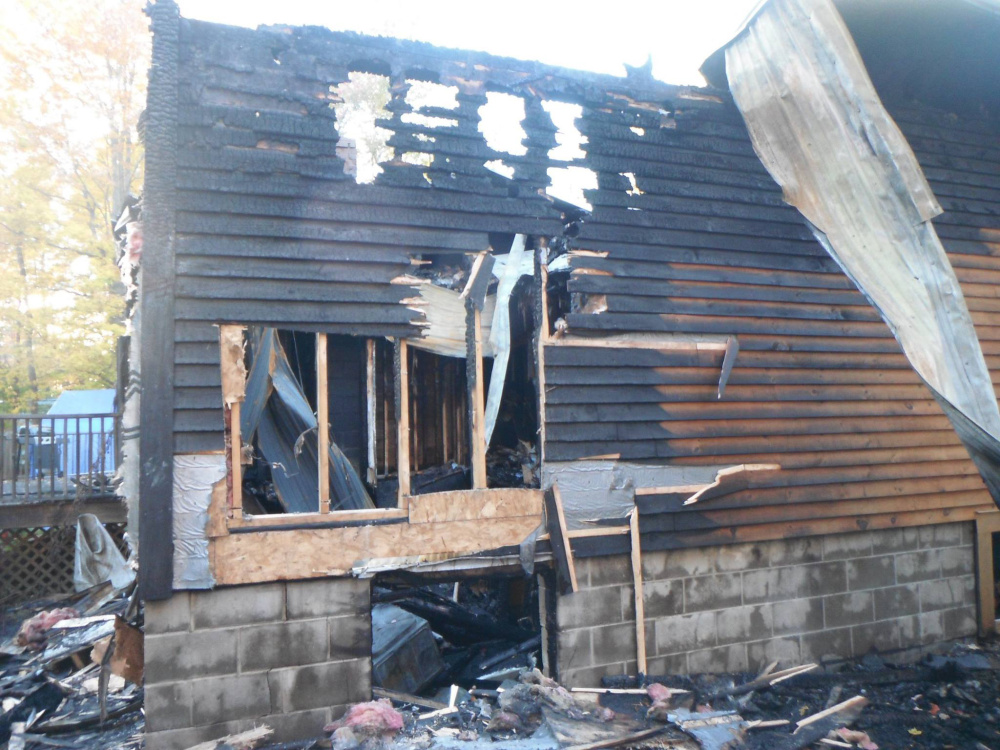 The back of the home at 120 Vacation Estates off Holley Road in Farmington Wednesday after a fire destroyed the house. The Bates family lost a number of pets.