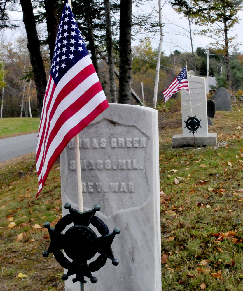 Two grave markers sport traditional Revolutionary War markers at the Red Schoolhouse Cemetery in Farmington on Tuesday. The town removed some of the markers to give to the Farmington Historical Society for safe-keeping, but the Daughters of the American Revolution protested, saying the removal violates state law.