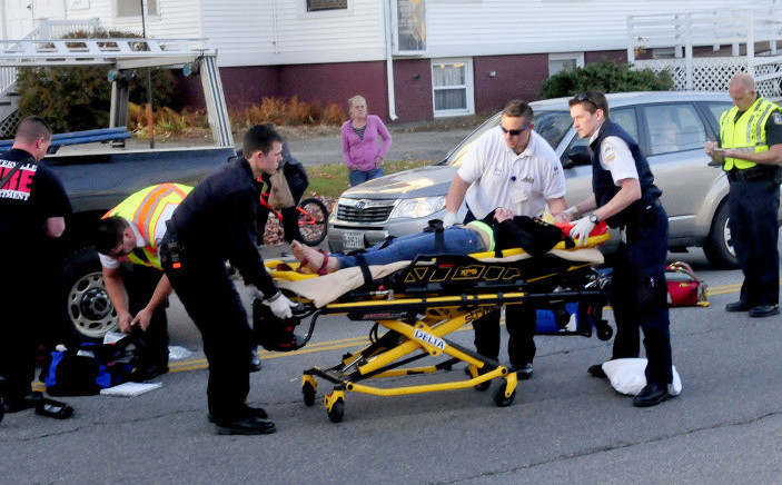 An injured teenager is carried to an ambulance after she ran into an SUV while crossing Silver Street in Waterville on Wednesday. The girl, who was taken to Inland Hospital, ran out into the street from between two vehicles that were stopped at a red light, police and witnesses said.