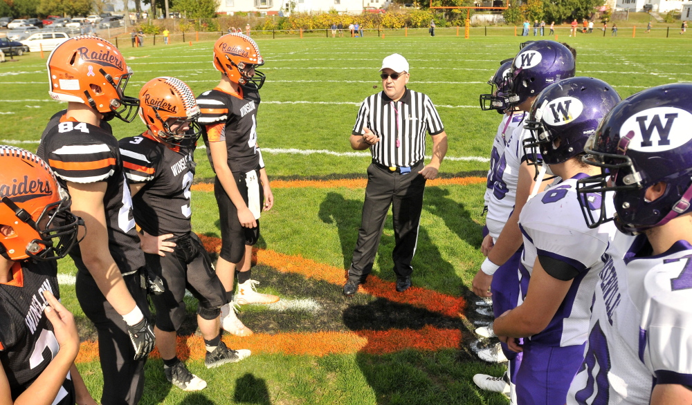 Members of the Waterville and Winslow football teams get ready for the coin toss before the annual Battle of the Bridge last season in Winslow.