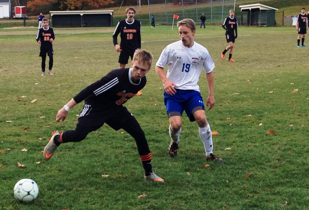 Staff photo by Evan Crawley 
 Brewer's Tyler Timms looks to get control of the ball in front of Messalonskee's Keenan Estes during a Class A North prelim game Saturday in Oakland.