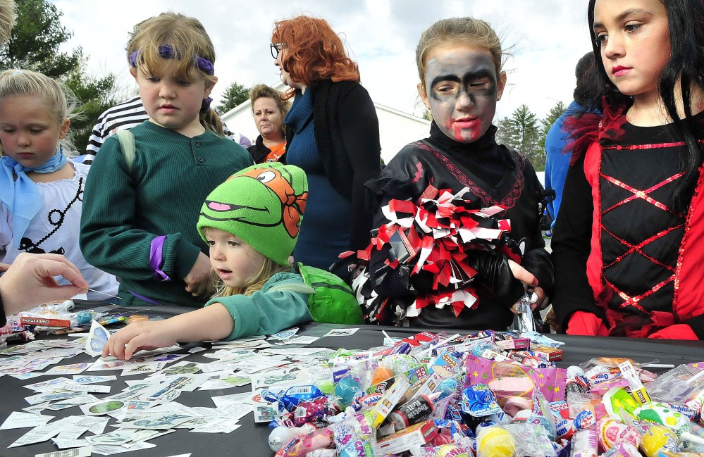 Kids dressed up for Halloween crowd around one of 30 vehicles and owners for candy during a trunk or treat event at the Canaan Elementary school on Oct. 26, 2014.
