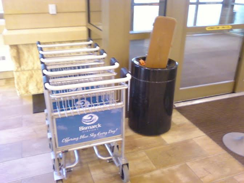 The gun case sticks out of a trash bin at the airport terminal.