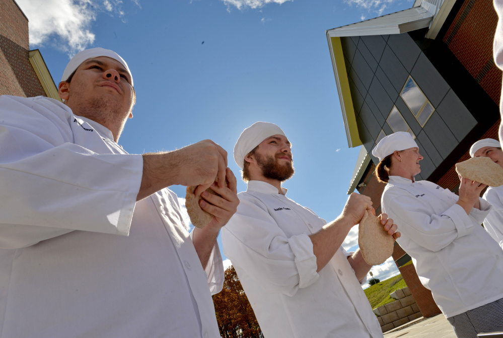 Culinary students at Kennebec Valley Community College, from left to right, Anthony Casoria, Justin Cash and Denise Barton, prepare pizza dough as they fire up the wood oven for class at the Alfond campus on Friday.