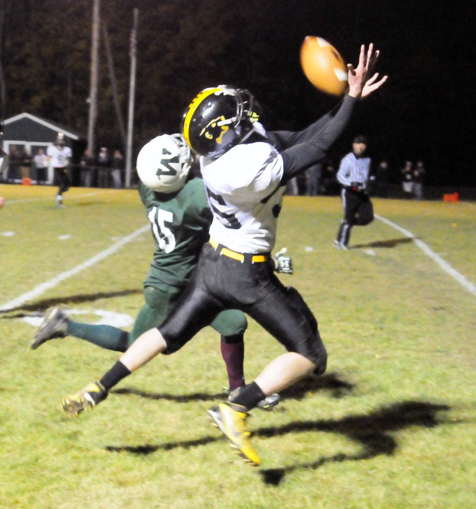 Winthrop/Monmouth receiver Andrew Pazdziorko, left, and Maranacook  linebacker Liam McNamara go after a pass during a Campbell Conference Class D quarterfinal game against Friday night at Maxwell Field in Winthrop.