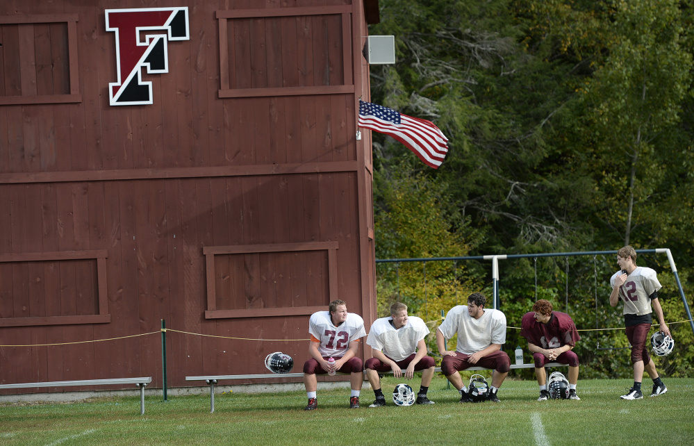 Freeport High football players – from left, Tucker Ginn, Edward Lefebvre, Brandon Cass, Eli Fox and Brady LaFrance – take a break during practice last week. The roster is slowly growing, but coach Paul St. Pierre says, “I know a lot of towns that are struggling.”